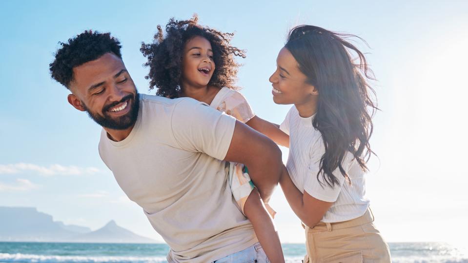 Cropped shot of an affectionate young family of three taking a walk on the beach