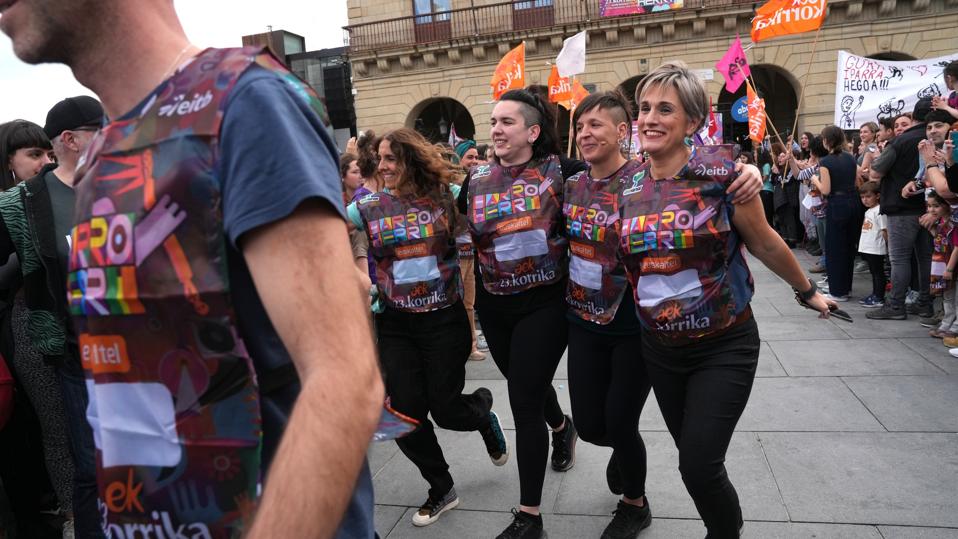 People wearing colorful vests and waving flags