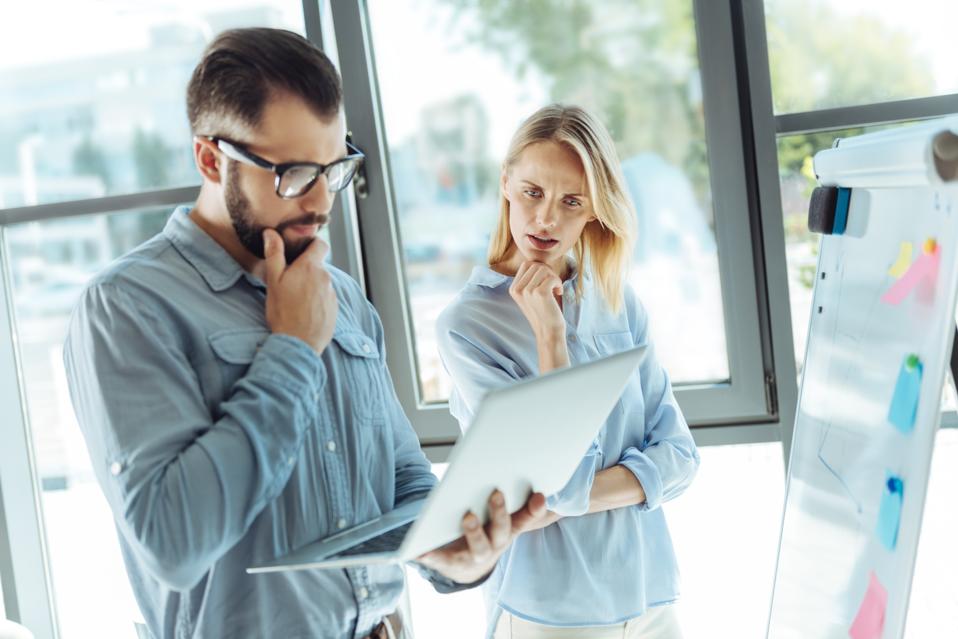 Young colleagues pondering over the problem solution