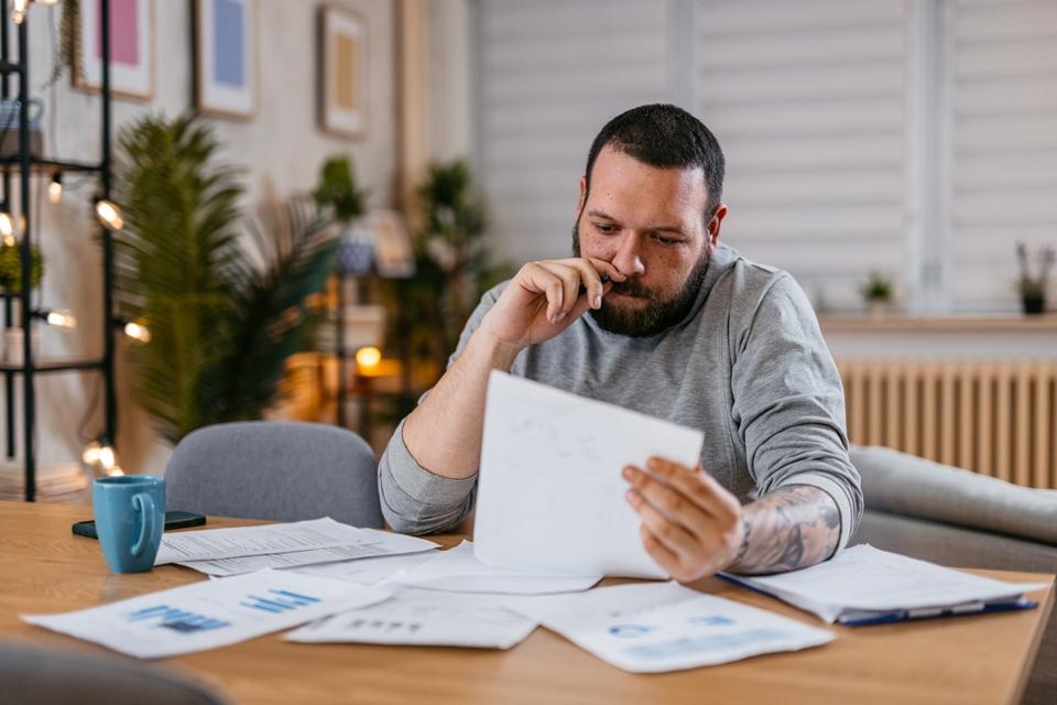 Man checks investing statements and reports at home. 