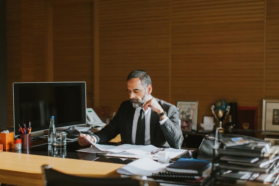 CEO working on his laptop in a modern office.