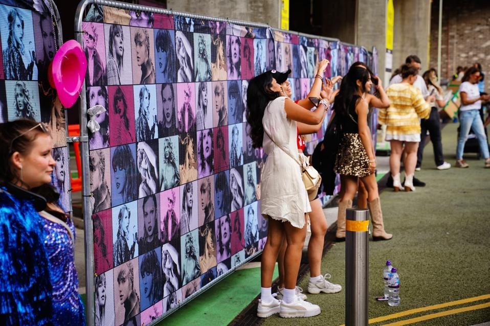 Daytime street view: Taylor Swift merchandise at Wembley Park, Concert crowd at Wembley Stadium Taylor Swift - the Eras Tour concert In London United Kingdom