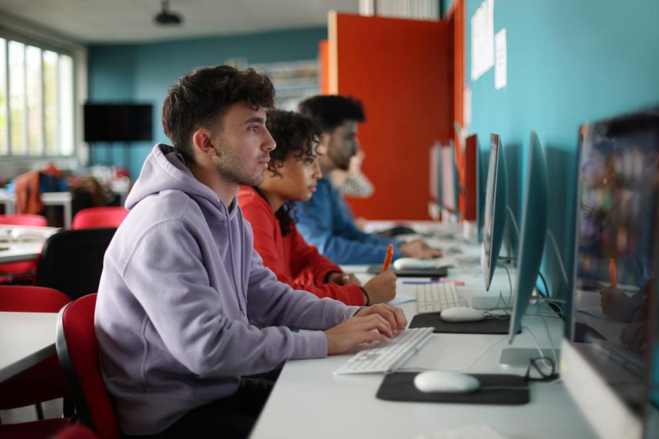A group of students working on a computer during a college course