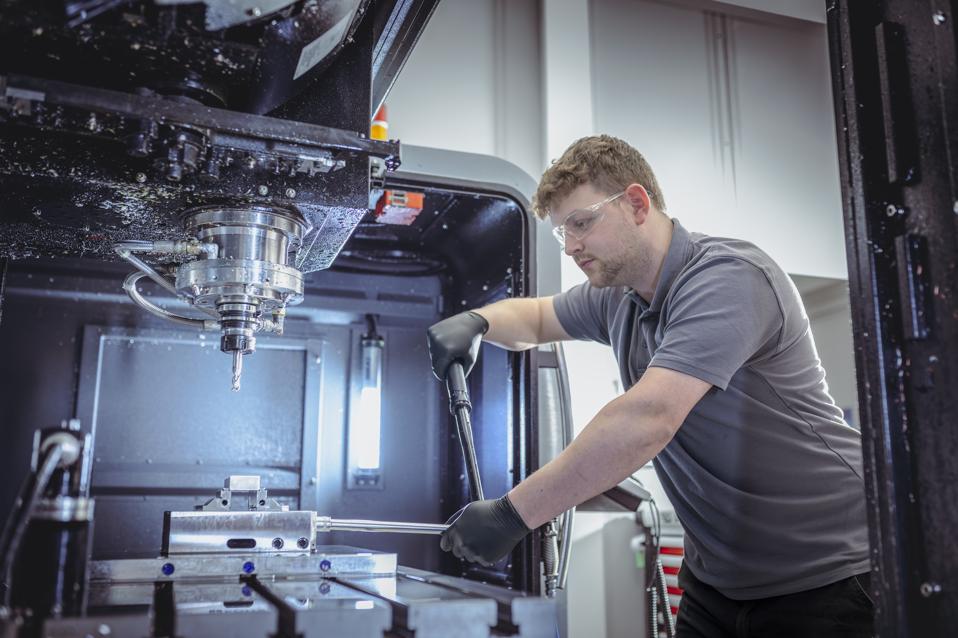 Engineer with CNC lathe in Nuclear Fusion reactor research factory