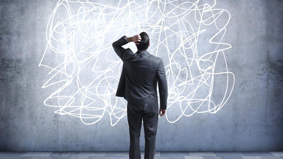 Confused businessman staring at scribble on wall
