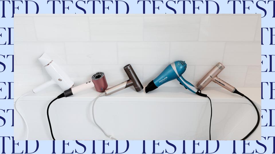 Five hair dryers with a white tile background