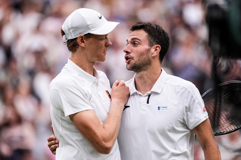 Jannik Sinner commiserates with Pedro Martinez after making it to the last 16 at Wimbledon