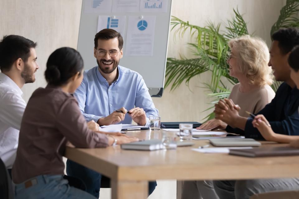 Diverse colleagues collaborate at a table, developing high-income skills during a creative brainstorming session in a modern office.
