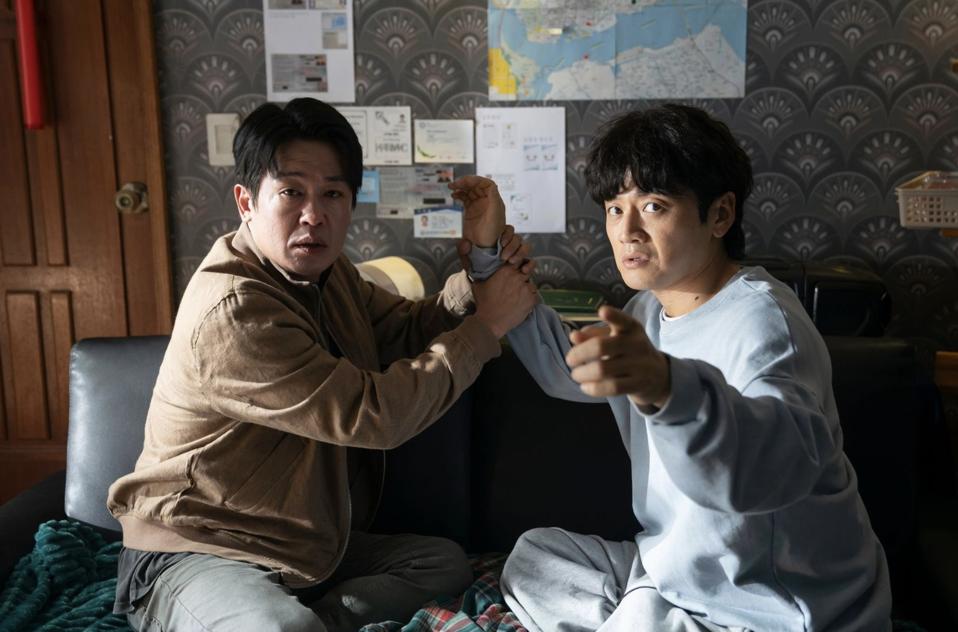 A detective holds the arm of an informant.