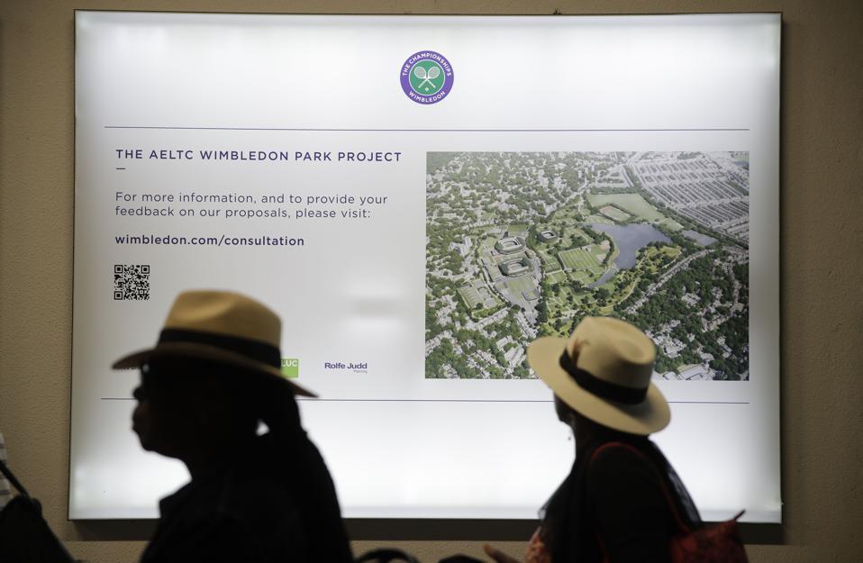 Spectators walk past plans for the All England Club's plans for Wimbledon expansion.