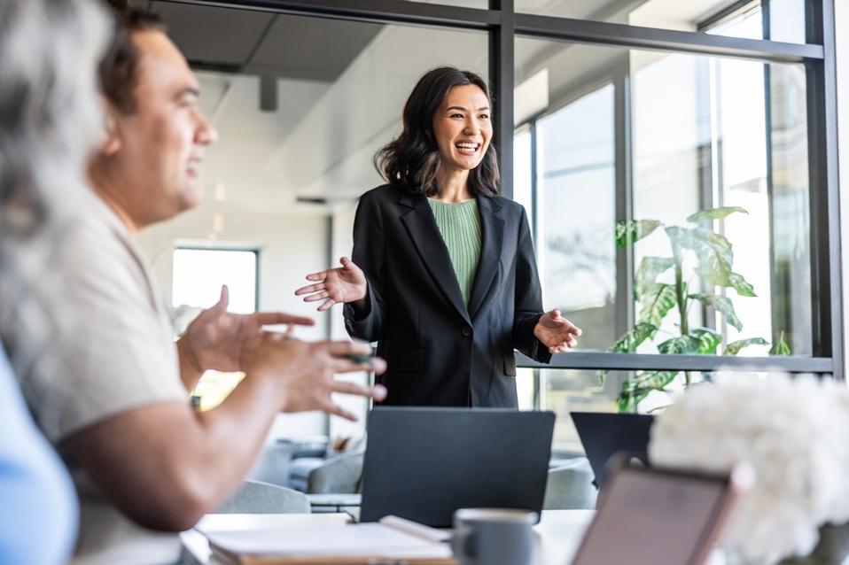 Young businesswoman addressing colleagues in a modern conference space