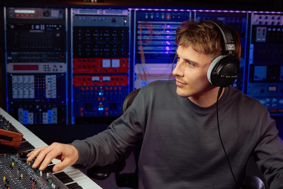 Man at music keyboard wearing beyerdynamic DT 990 PRO X headphones