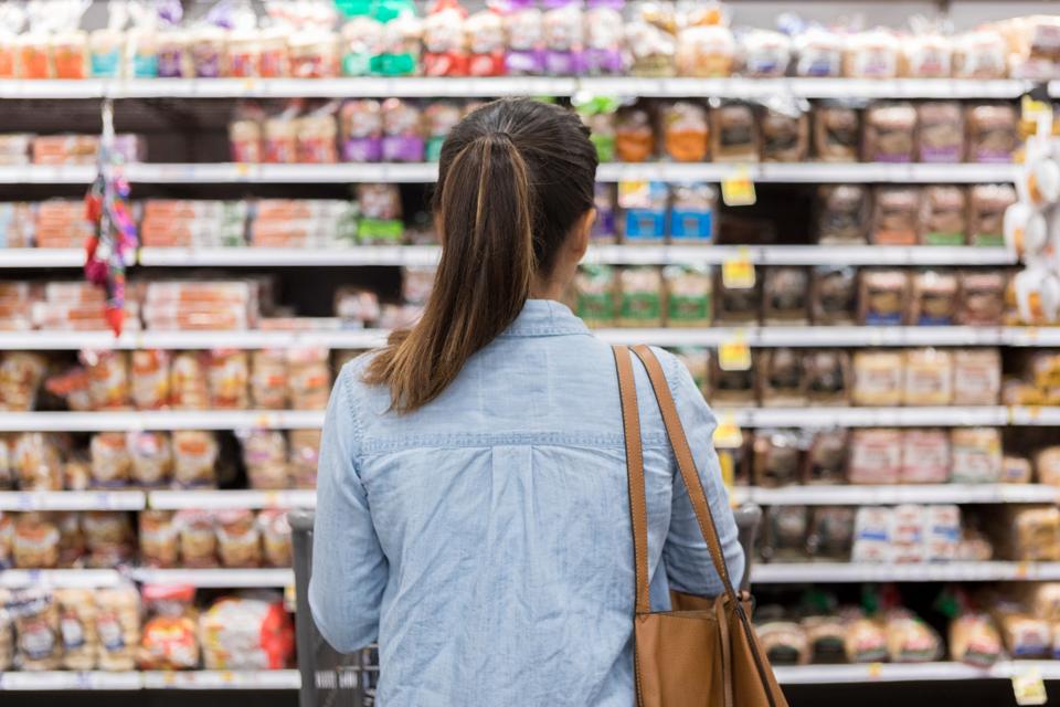 Unrecognizable woman marvels at grocery bread selection