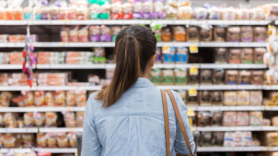 Unrecognizable woman marvels at grocery bread selection