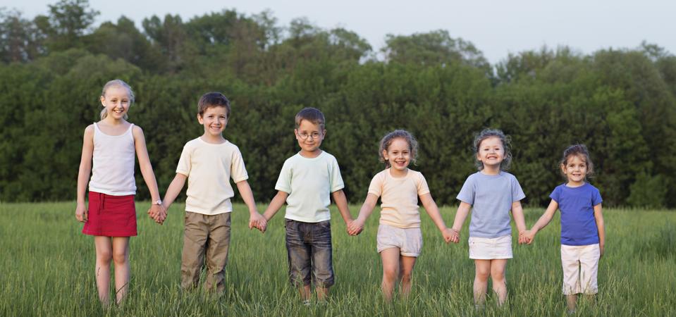 Portrait of children holding hands in a field