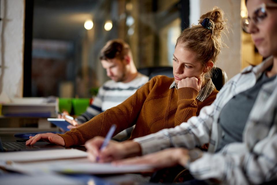 Bored office worker at desk, showing quiet cracking habits and disengagement that can stall career growth.