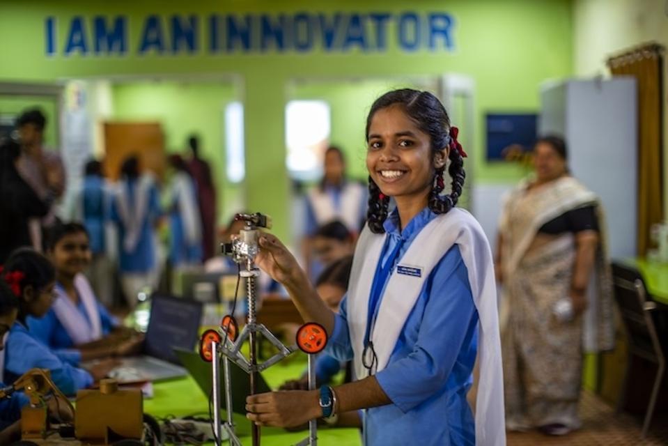 A girl holds the sewer cleaning robot she developed in a UNICEF-supported program in Chhattisgarh, India.