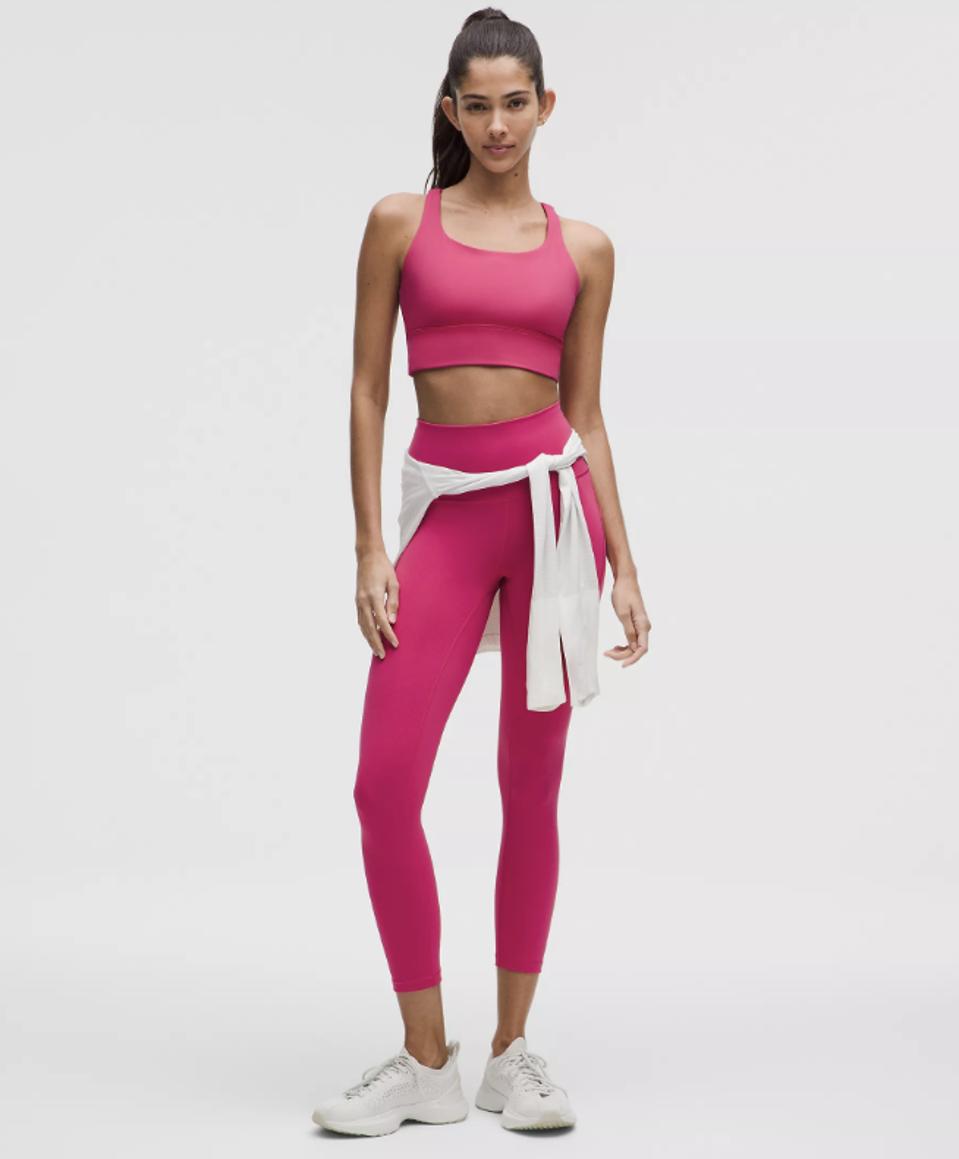 Model wearing Lululemon Energy Longline Bra Medium Support in Raspberry Coulis.