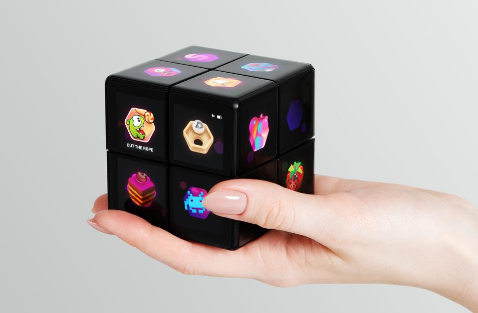 A Rubik's WOWCube sitting in someone's hand