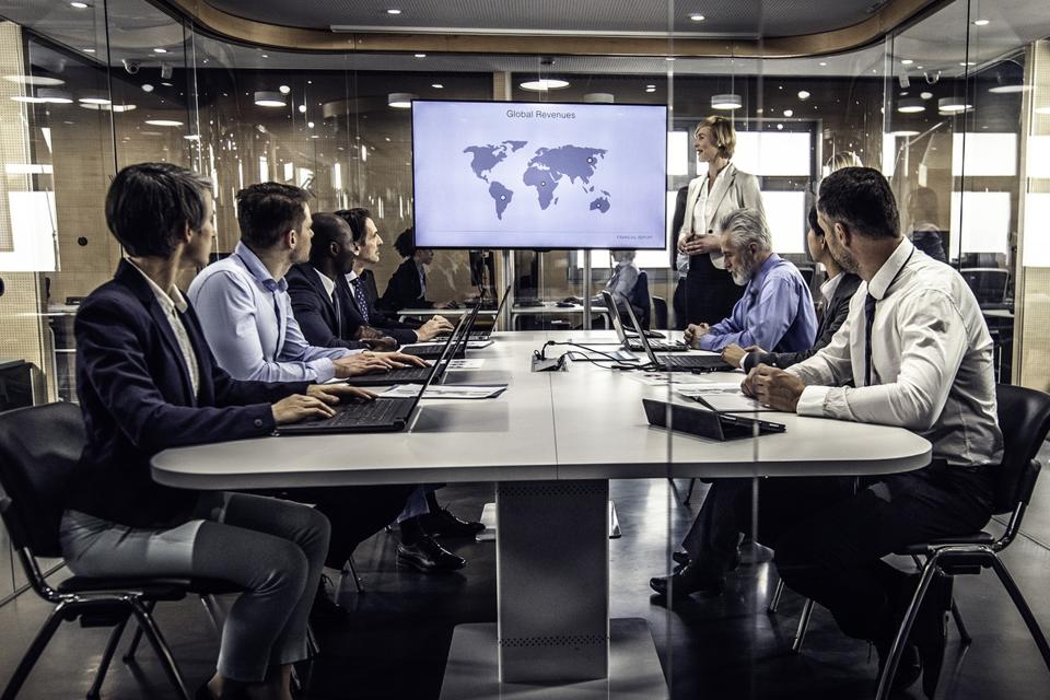 Corporate managers listening to a presentation in a conference room