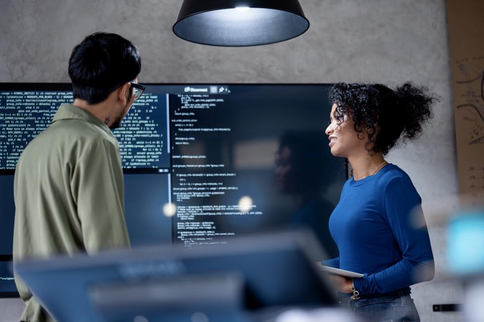 Involve People in Decisions to Improve Performance, Efficiency, and Productivity in Software Development. Diversity of team software developer on a software project discussion to define project timeline in a tech business office.