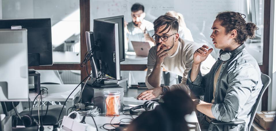 Two programmers at the office. They discuss and working on new project.