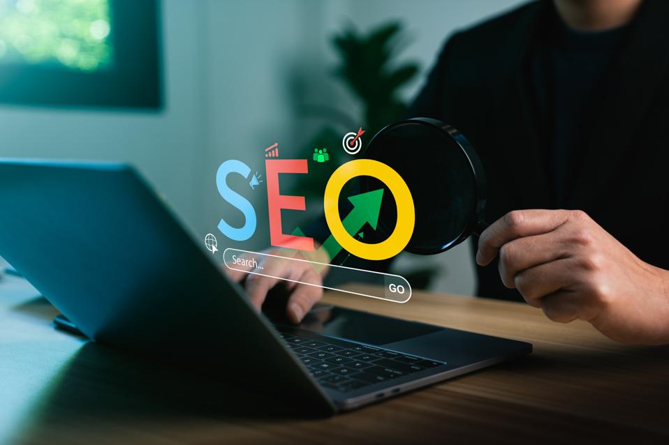 SEO strategy with magnifying glass over laptop. Boosting website traffic using AI