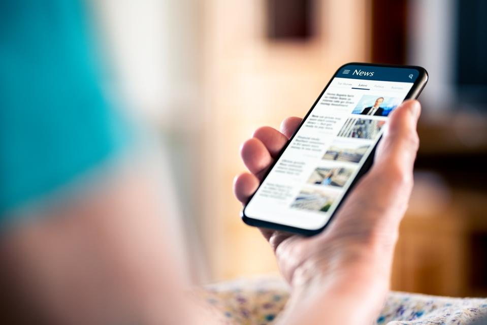 News online. Mobile phone screen. Senior woman reading newspaper on web portal and website. Latest daily information. Headlines on internet. Old person with smartphone.