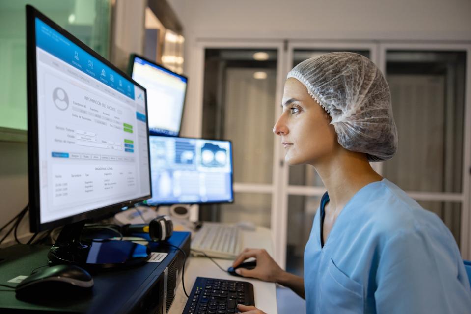 Les radiologues féminins de la salle de contrôle utilisent des logiciels informatiques pour examiner et saisir des données après avoir effectué une analyse médicale. Concept de technologie de santé.