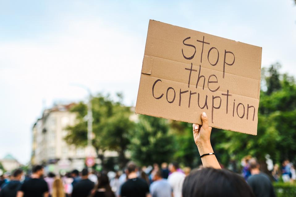 Young woman holding a poster against corruption. Human rights and democracy concept. Young activists concept.