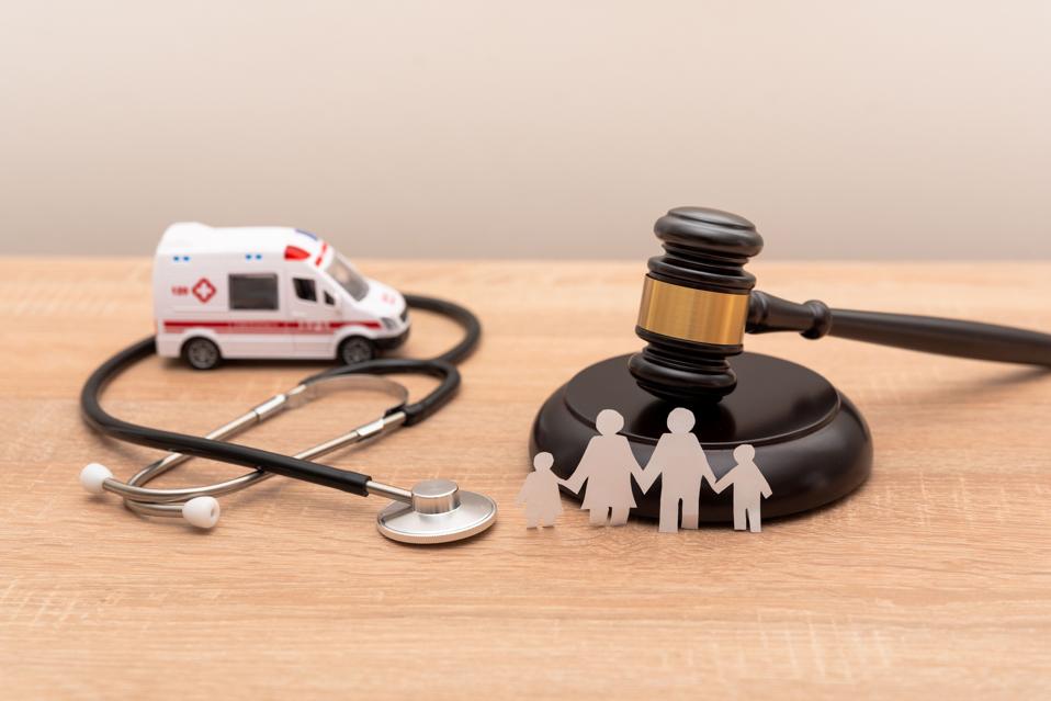 Family Health and Legal Issues with a Gavel, Stethoscope, Ambulance and Paper Family Figures
