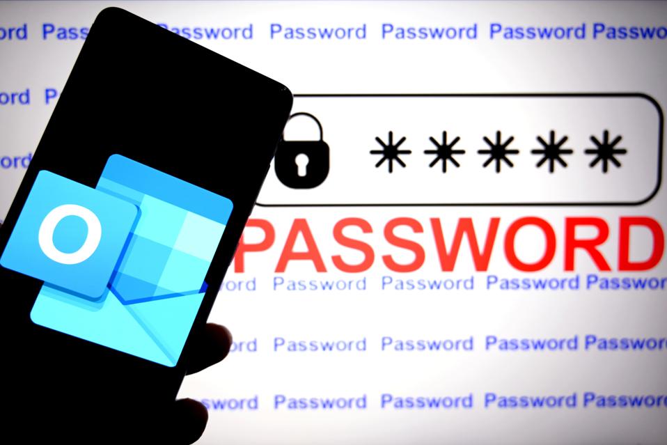 Microsoft Outlook logo is seen displayed on a smartphone with the words 'Password' in the background.