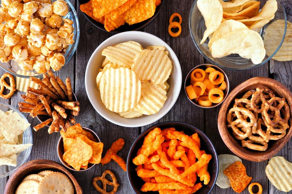 Mixed salty snack flat lay table scene on a wood background
