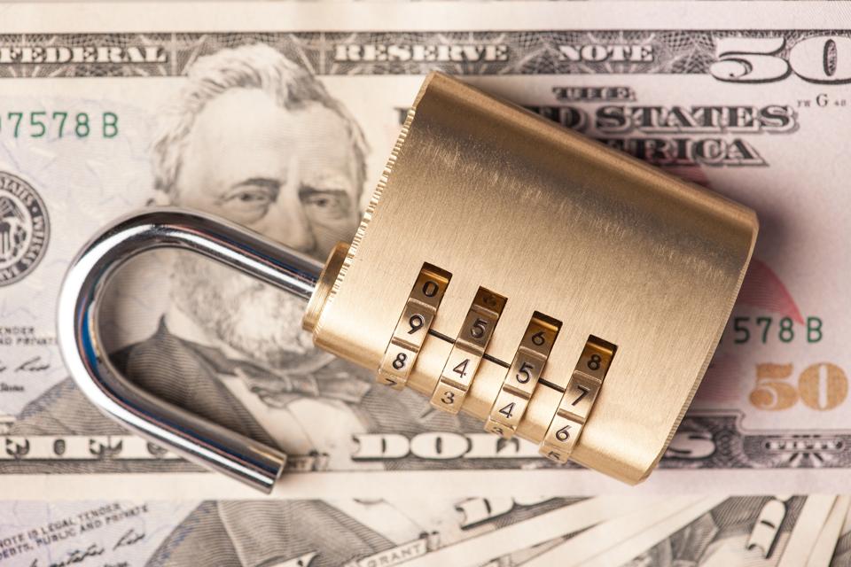 Unlocked padlock on American dollars