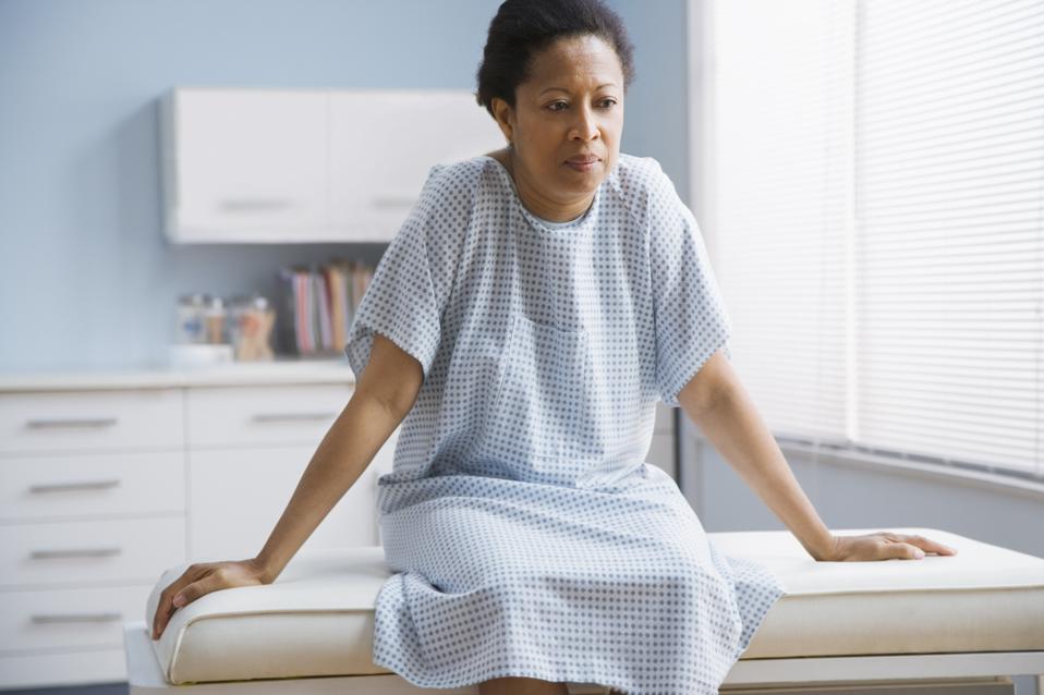 Female patient sitting on examination table in doctor's office