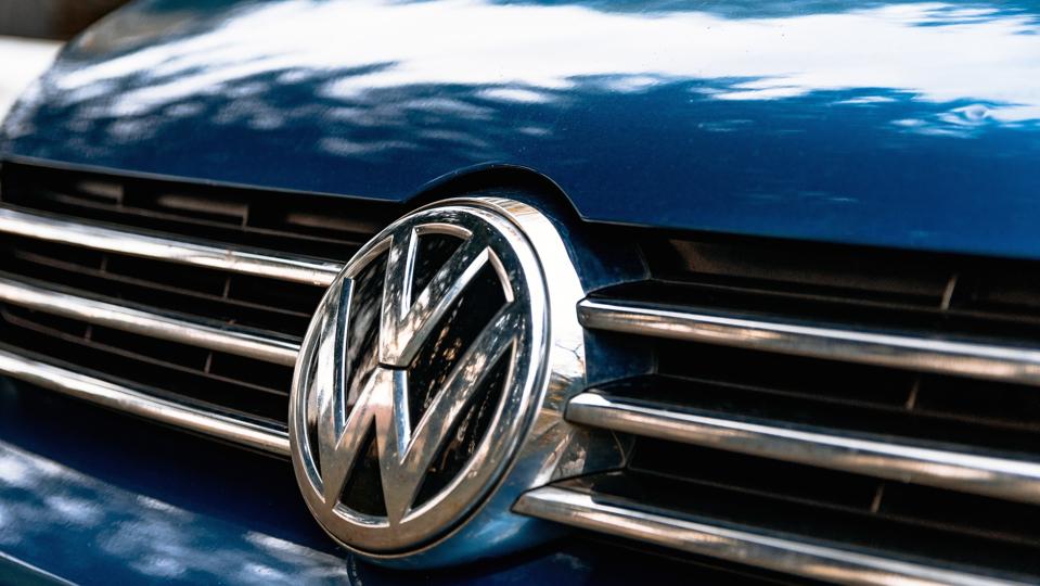 Closeup of a Volkswagen logo on the grille of a blue car