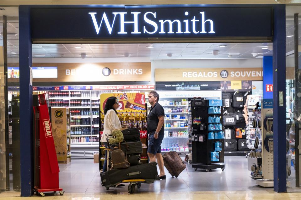 Flight passengers are seen shopping at a WHSmith store in Madrid Airport.