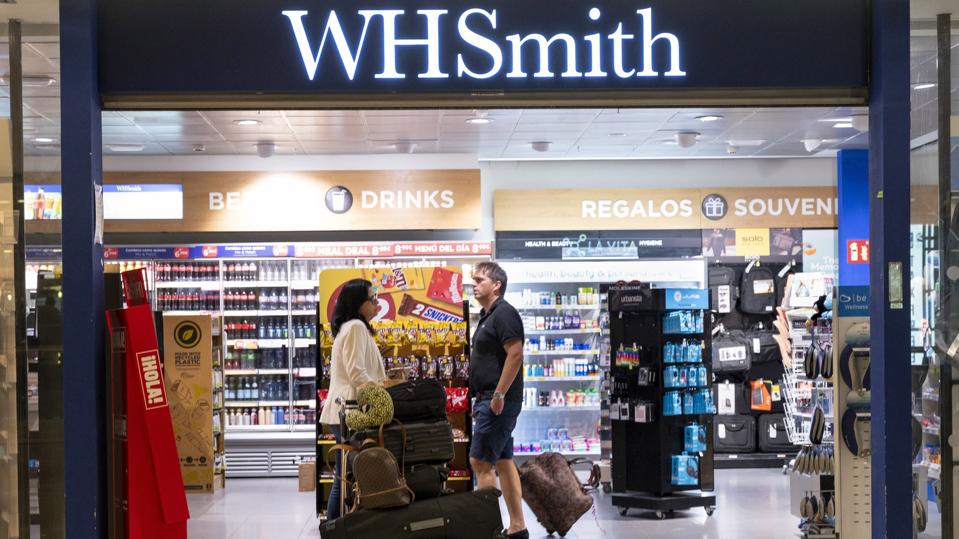 Flight passengers are seen shopping at a WHSmith store in Madrid Airport.