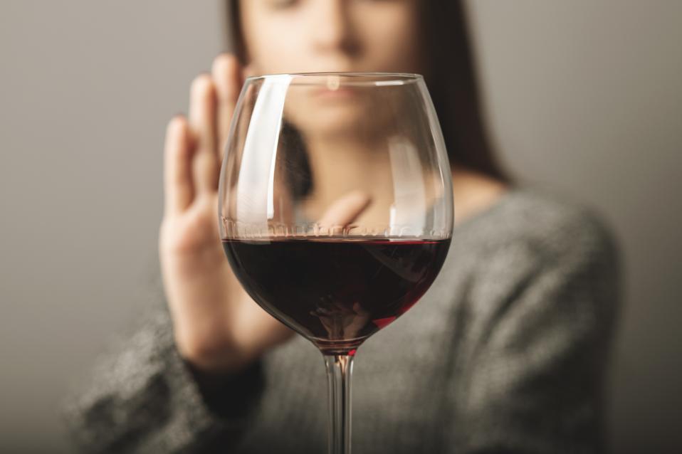 A young woman refusing a glass of wine