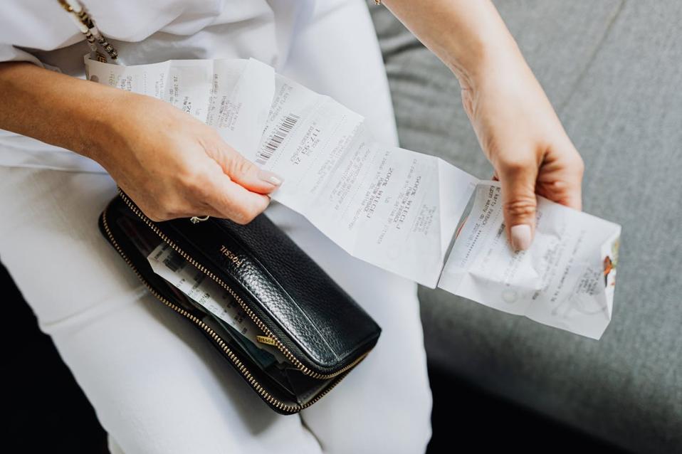 A woman review her latest receipt