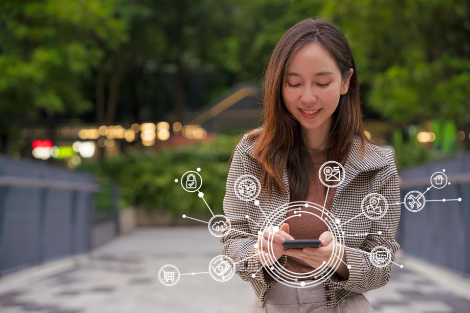 Business woman using smartphone with virtual various icons of smartphone technology. Artificial intelligence and communication network concept.