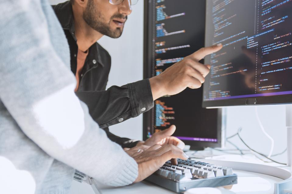 Hispanic Latin American couple, software engineer developer use computer, work on program coding together at home office. Programming language development technology, freelance job concept. Close up