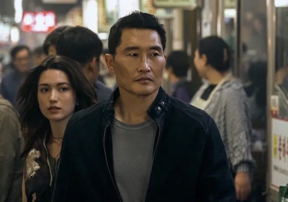 A father and daughter walk through a crowd.