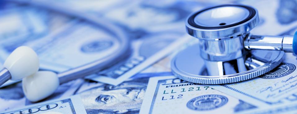 Close-up of a stethoscope on a spread U.S. $100 dollars bills. 