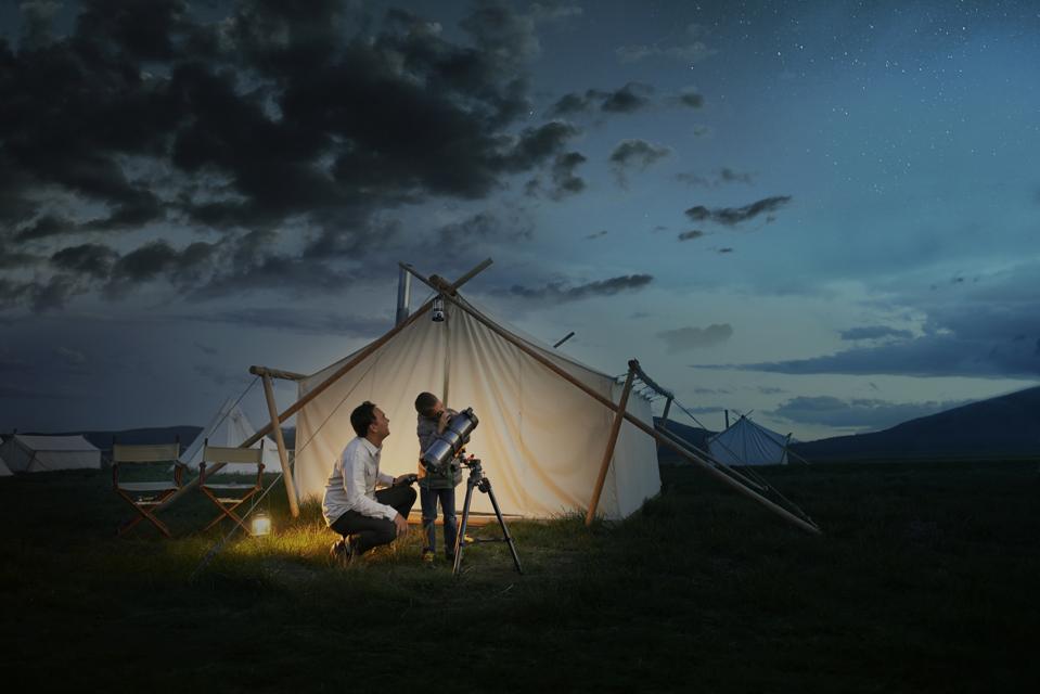 Father and son looking through telescope