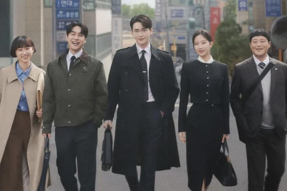 Five associate lawyers, three menaced two women, walk down a street.