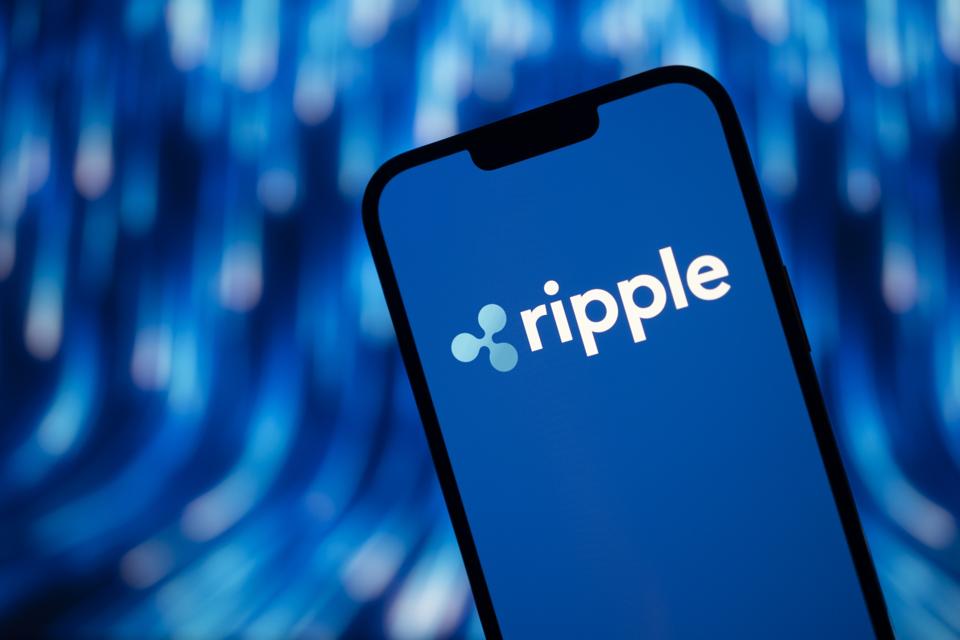 Ripple's logo on a phone for the topic of where will XRP be in 5 years?