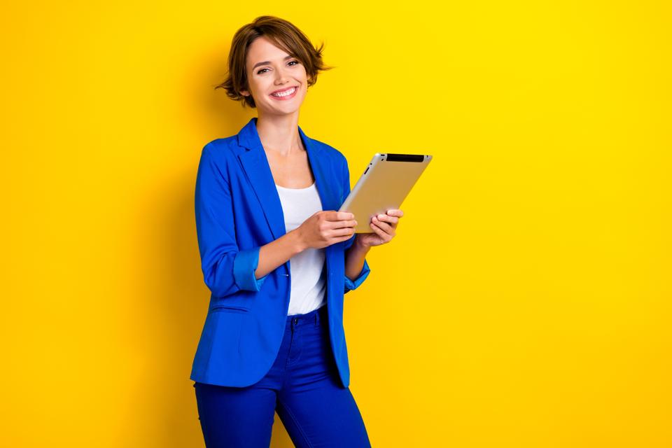 Photo of happy woman with tablet looking at her LinkedIn profile About