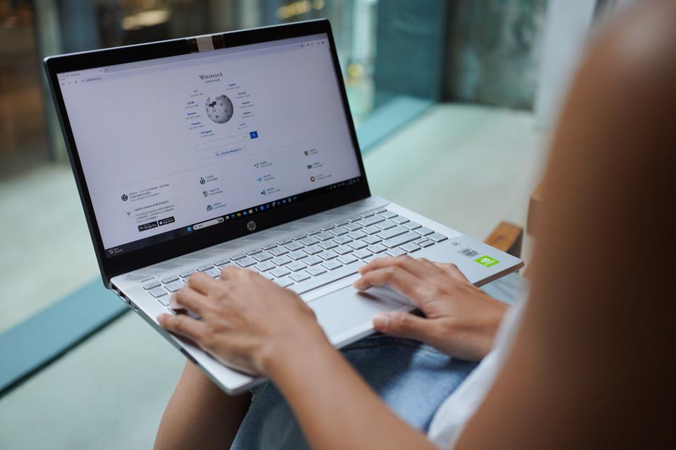 In this photo illustration, A woman browses Wikipedia...