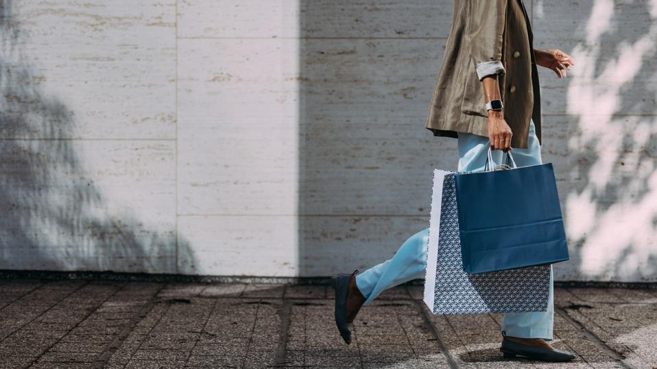 Woman Walking With Shopping Bags on City Street